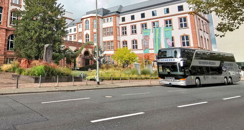 Saschas silberner Doppeldeckerbus vor dem Senckenberg Naturmuseum in Frankfurt am Main mit Dinosaurierstatue im Vorhof.