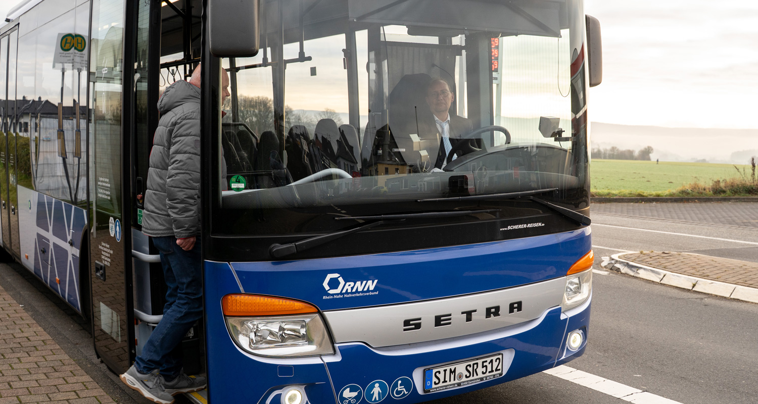 Mann steigt durch die Vordertür in einen Scherer-Reisen Linienbus.