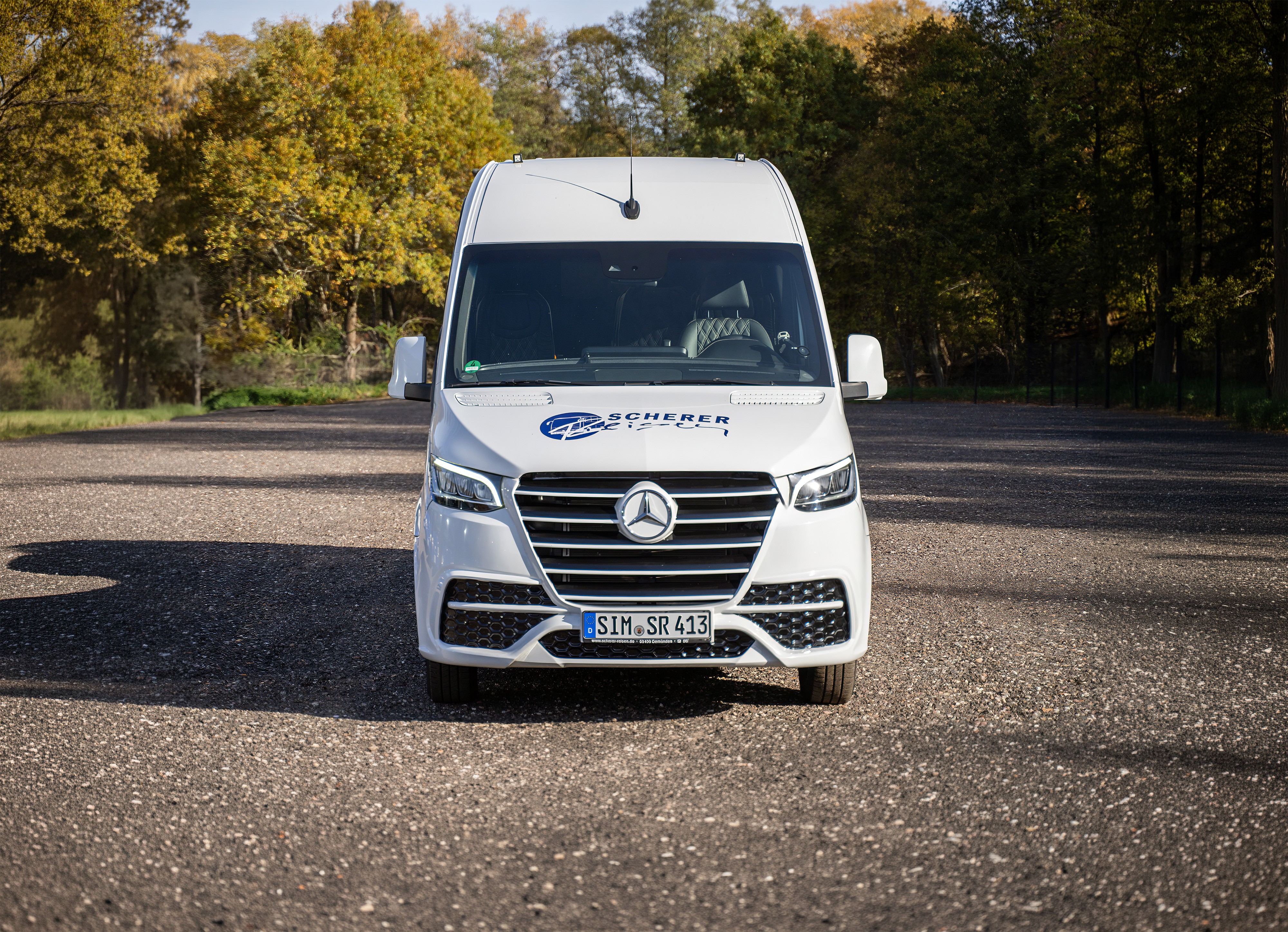 Frontalansicht eines weißen Scherer-Reisen Mercedes Benz VIP-Sprinter SR413.