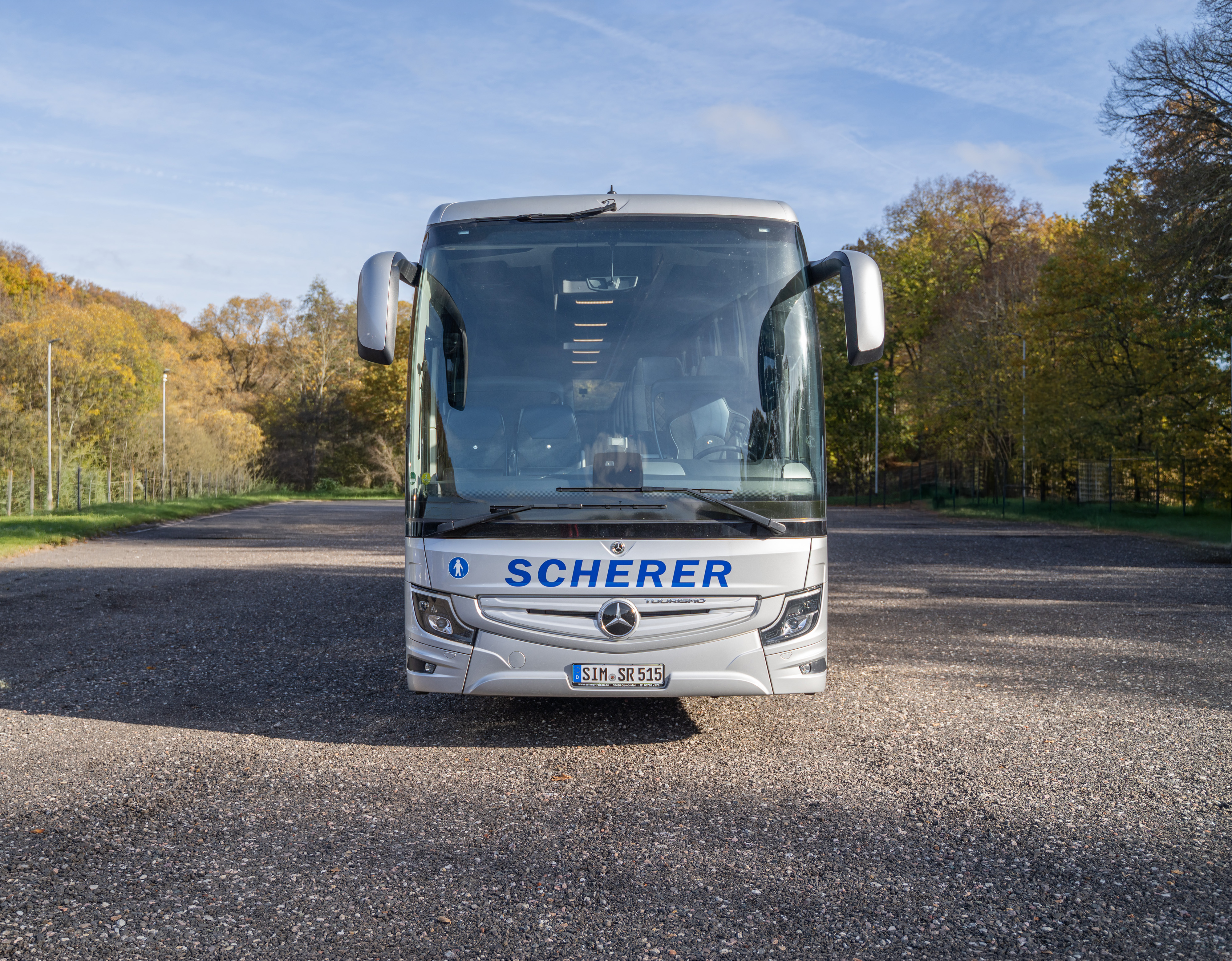 Frontalansicht eines silbernen Scherer-Reisen Busses.